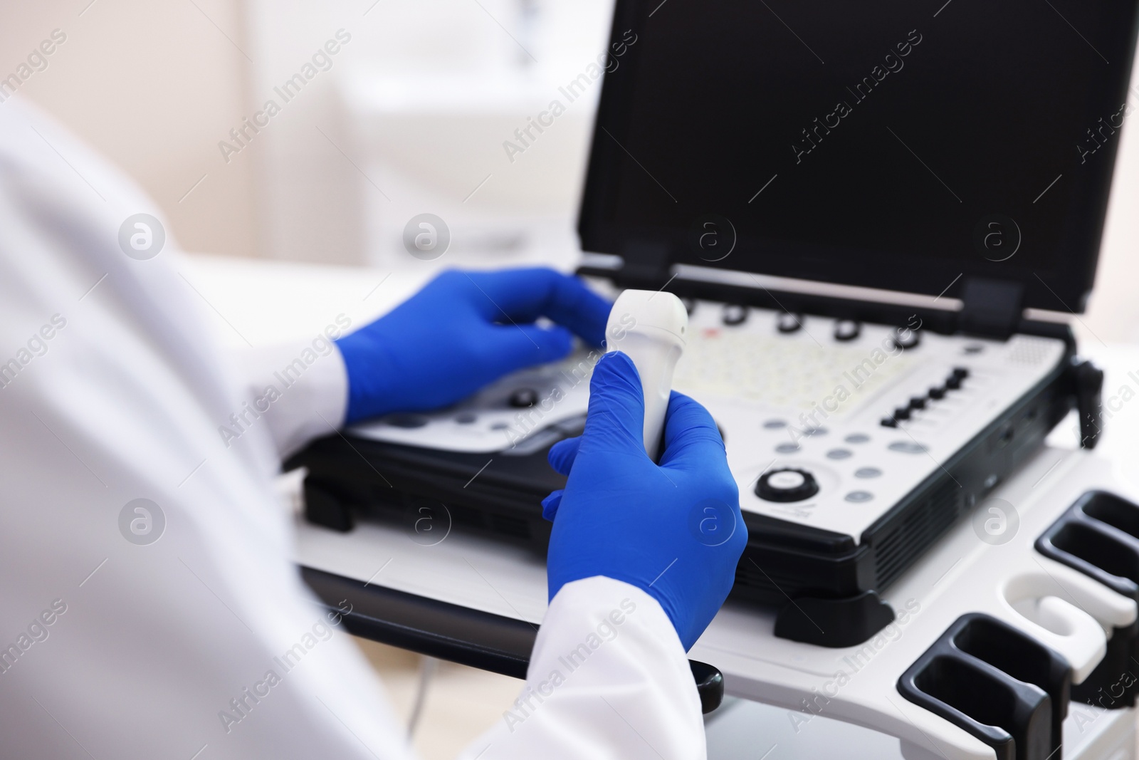 Sonographer with transducer and ultrasound machine in clinic, closeup Photo of Sonographer with transducer and ultrasound machine in clinic, closeup