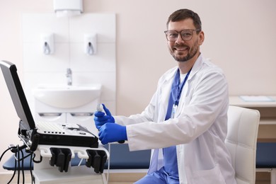 Photo of Professional sonographer with ultrasound machine in clinic