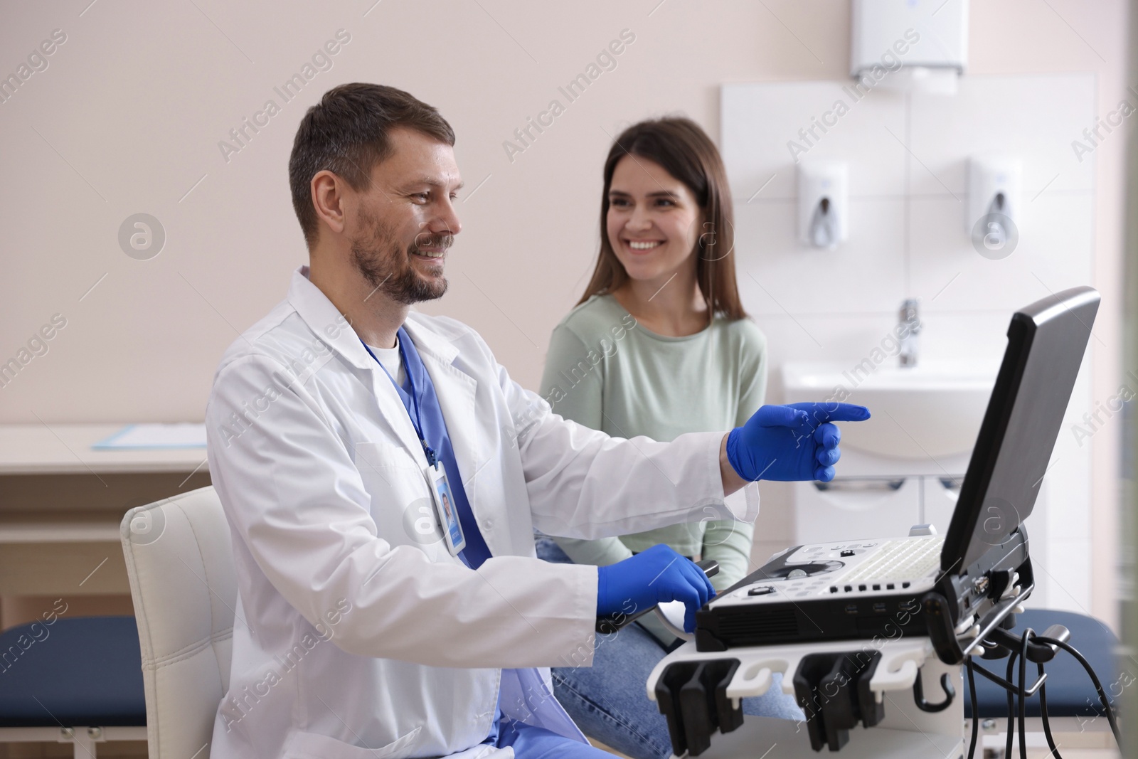 Sonographer showing woman her ultrasound imaging on screen in clinic Photo of Sonographer showing woman her ultrasound imaging on screen in clinic