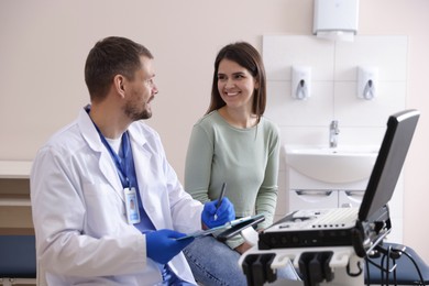 Photo of Sonographer consulting woman before her ultrasound examination in clinic