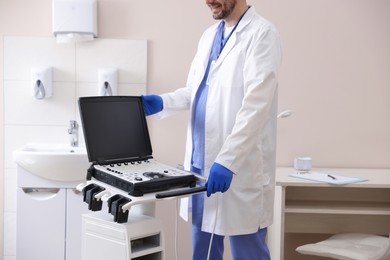 Photo of Professional sonographer with ultrasound machine in clinic, closeup