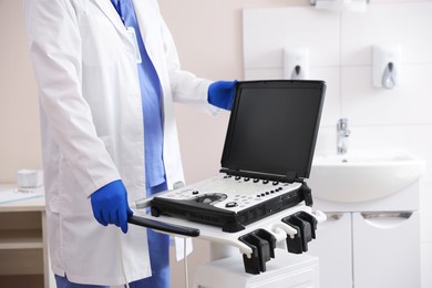 Photo of Professional sonographer with ultrasound machine in clinic, closeup