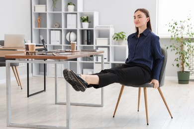 Photo of Beautiful woman exercising with chair in office