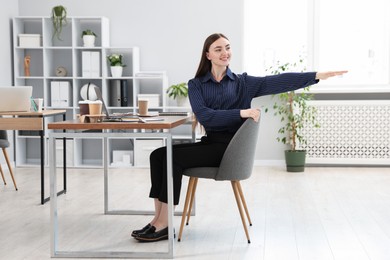 Photo of Beautiful woman stretching on chair in office