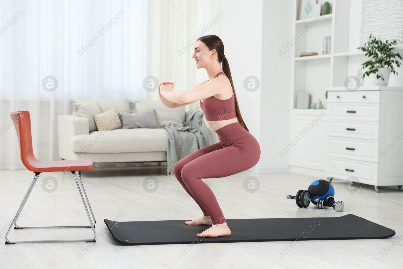 Beautiful woman exercising on fitness mat at home Photo of Beautiful woman exercising on fitness mat at home