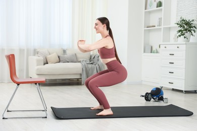 Photo of Beautiful woman exercising on fitness mat at home