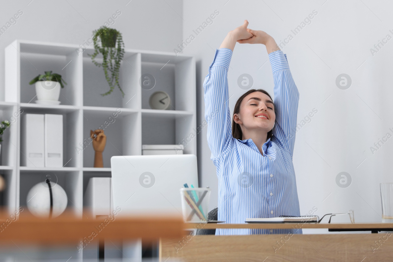 Beautiful woman stretching on chair in office Photo of Beautiful woman stretching on chair in office
