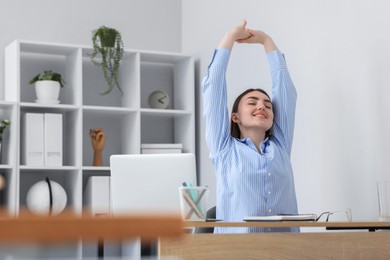 Photo of Beautiful woman stretching on chair in office