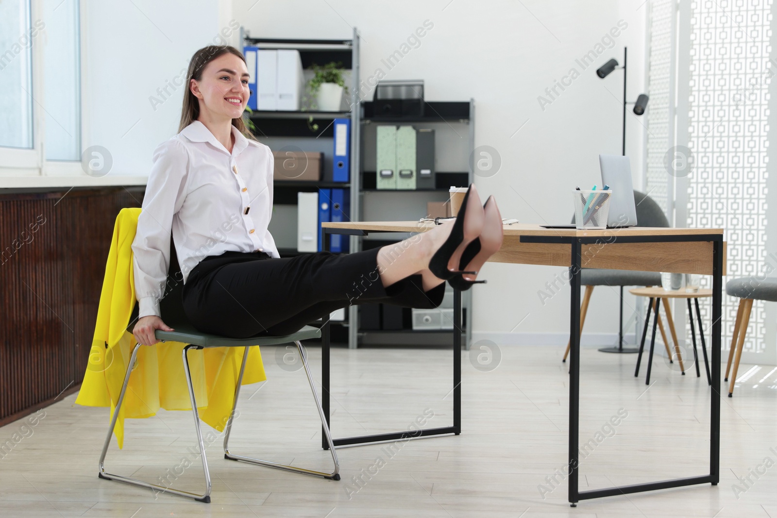 Beautiful woman exercising with chair in office Photo of Beautiful woman exercising with chair in office