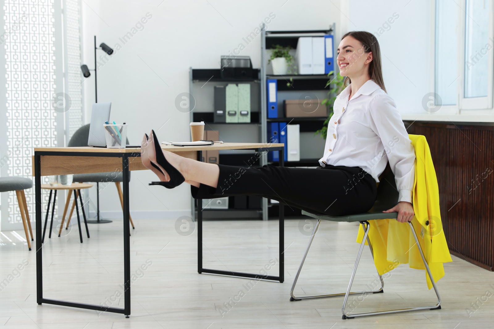 Beautiful woman exercising with chair in office Photo of Beautiful woman exercising with chair in office