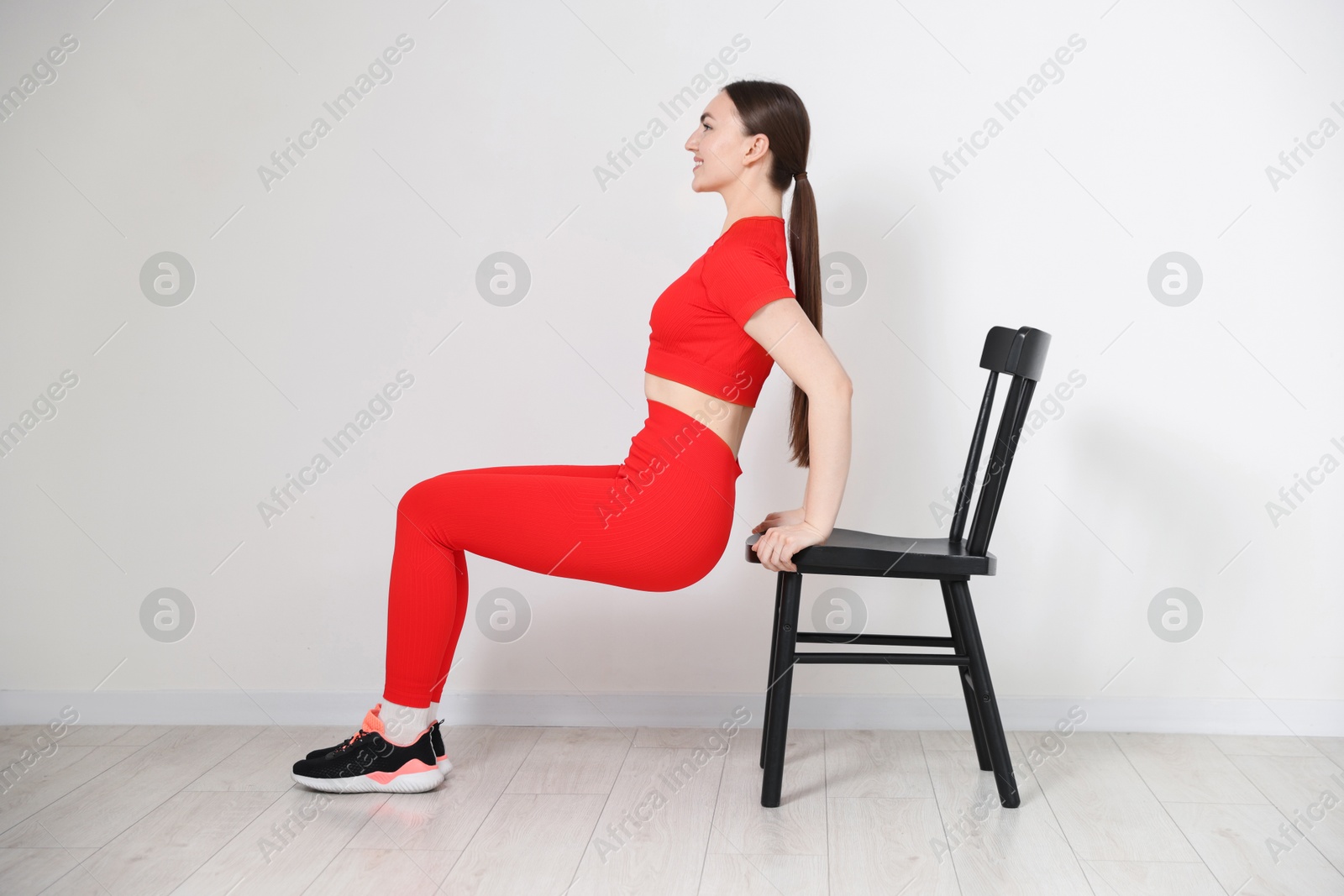 Beautiful woman exercising with chair at home Photo of Beautiful woman exercising with chair at home