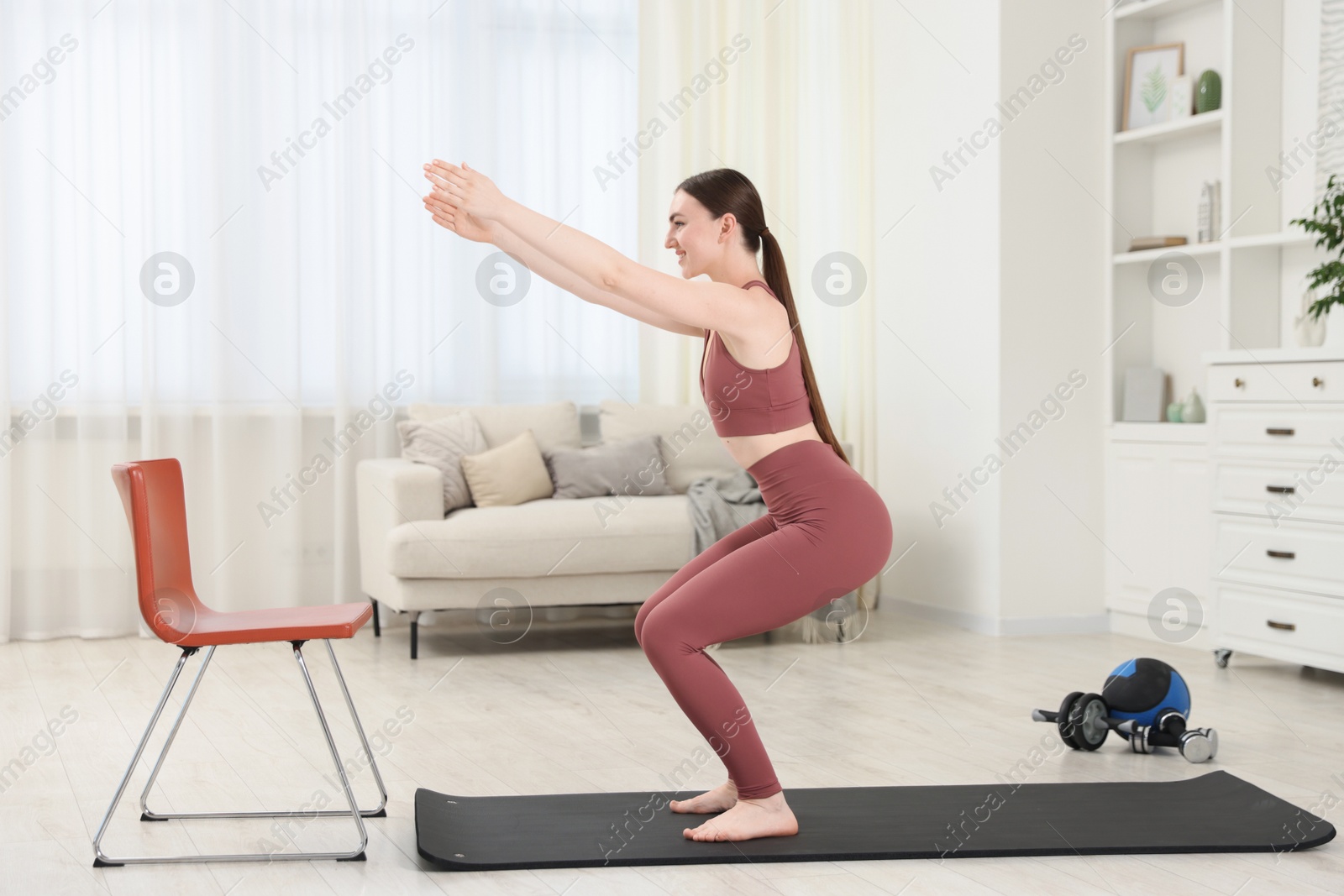 Beautiful woman exercising on fitness mat at home Photo of Beautiful woman exercising on fitness mat at home