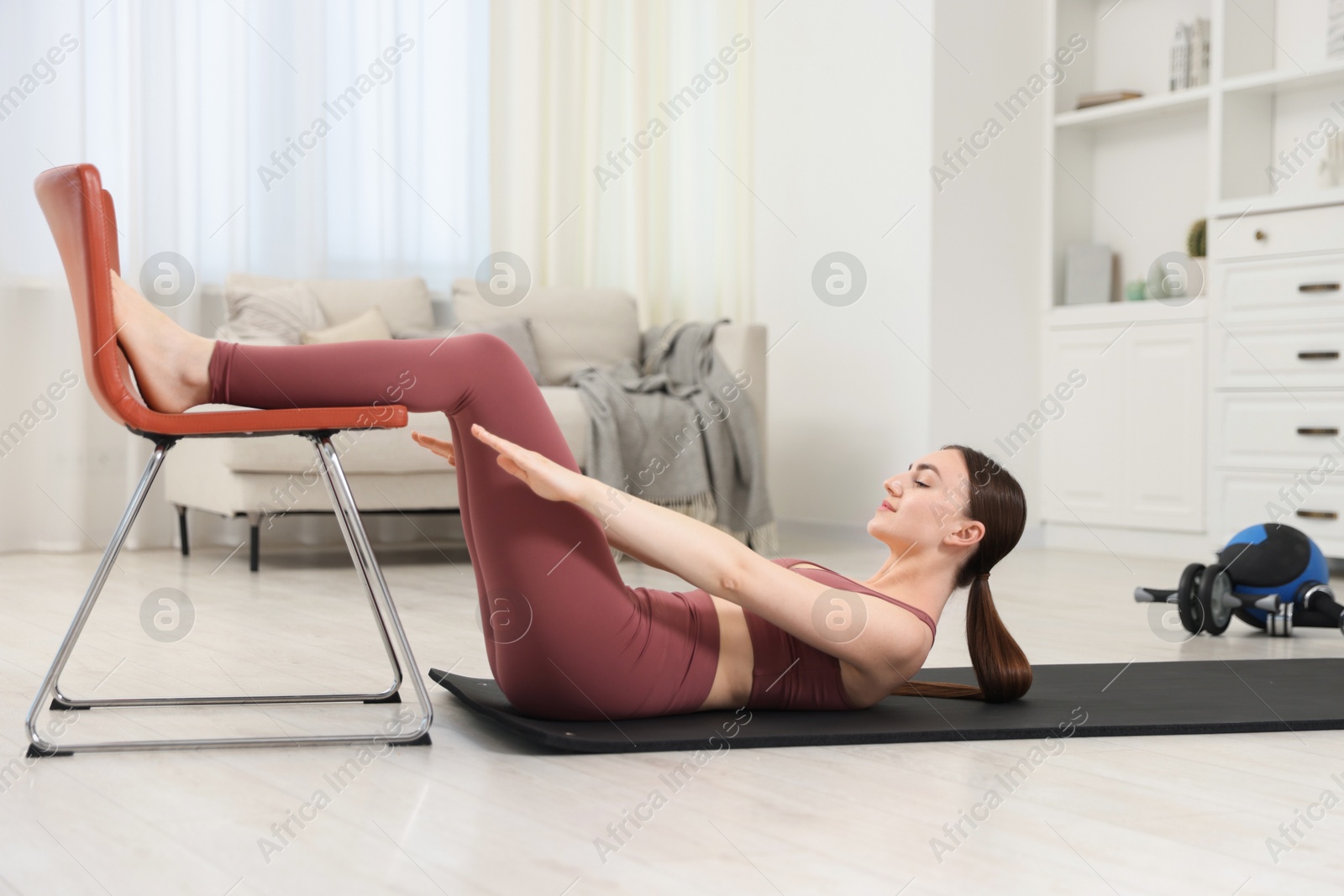 Beautiful woman exercising with chair at home Photo of Beautiful woman exercising with chair at home