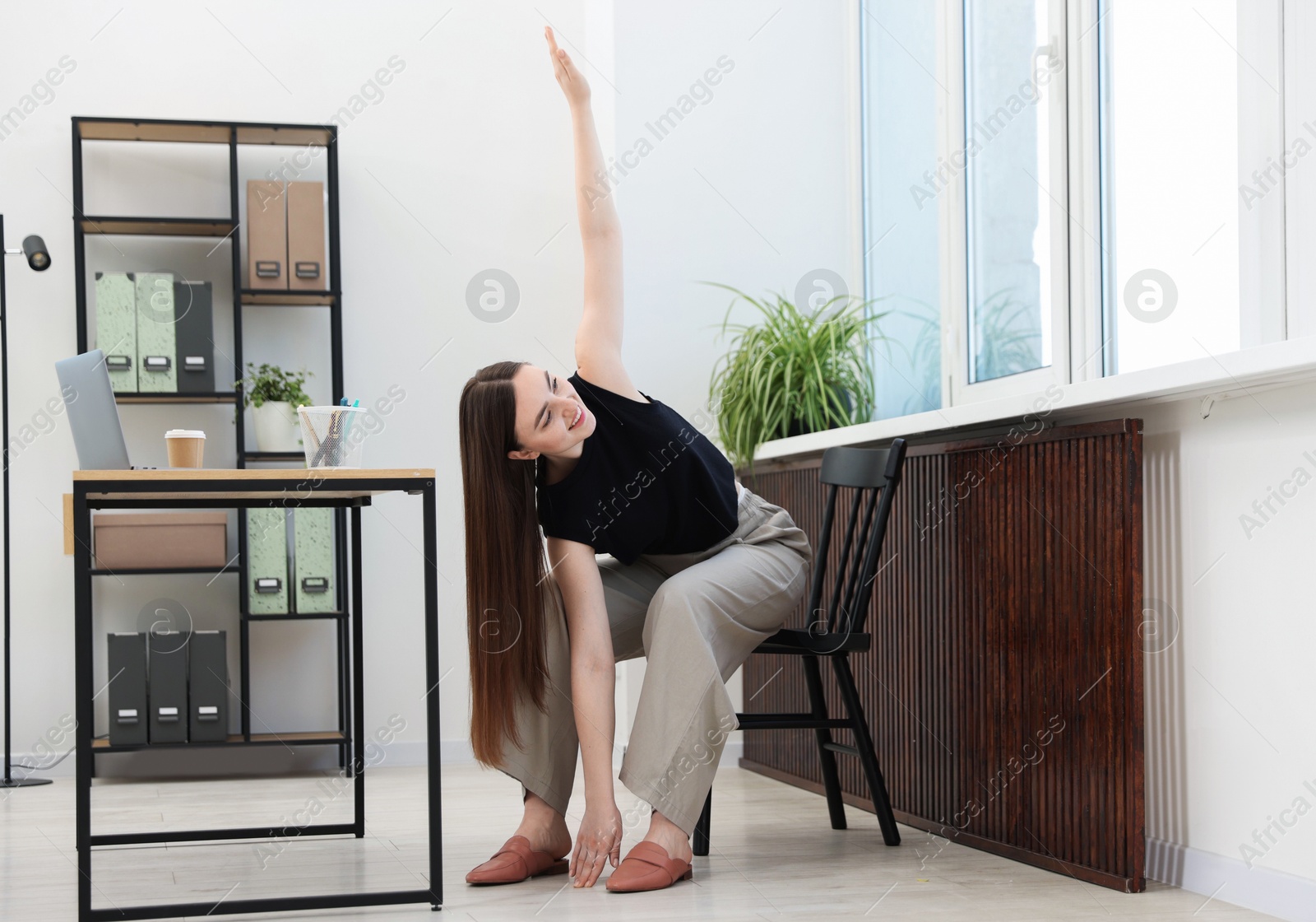 Beautiful woman stretching on chair in office Photo of Beautiful woman stretching on chair in office
