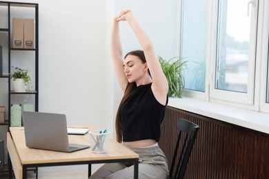 Photo of Beautiful woman stretching on chair in office