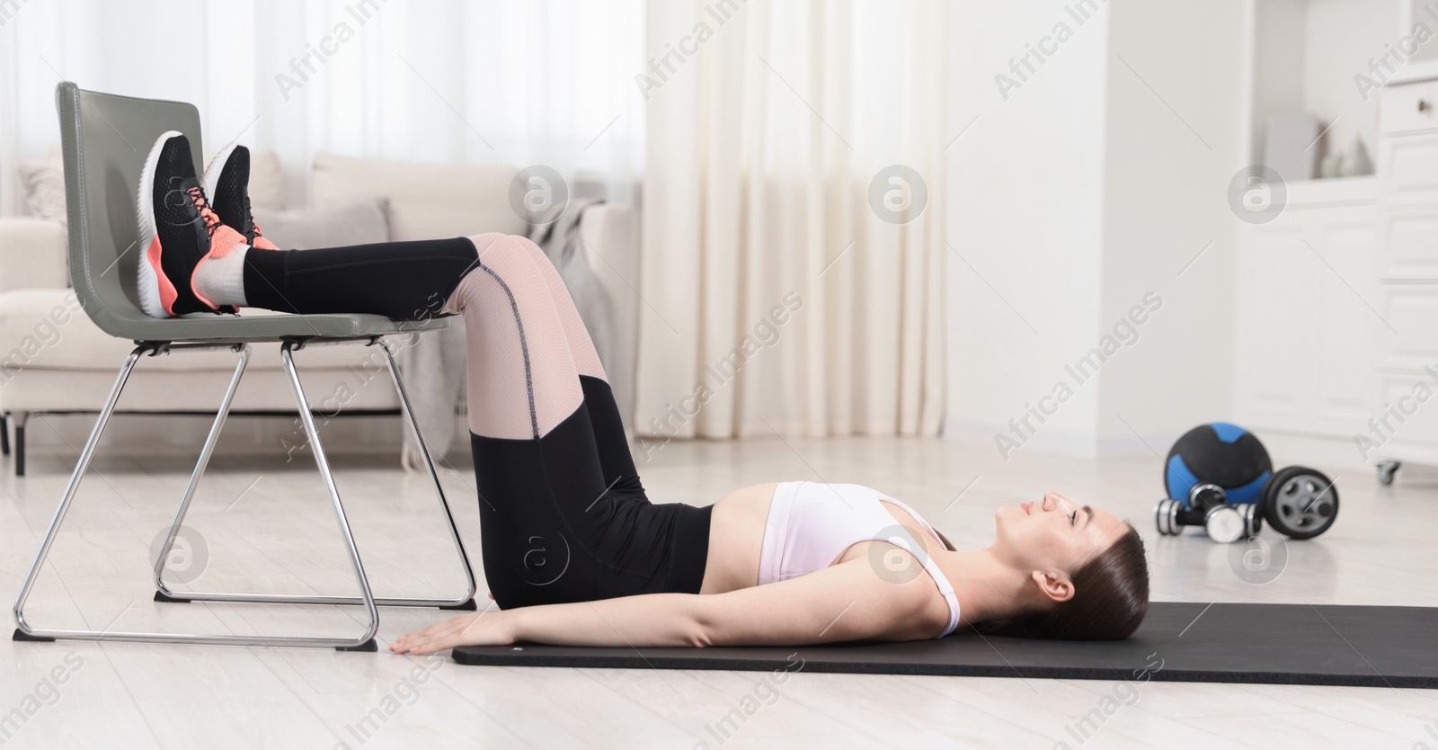 Beautiful woman exercising with chair at home Photo of Beautiful woman exercising with chair at home