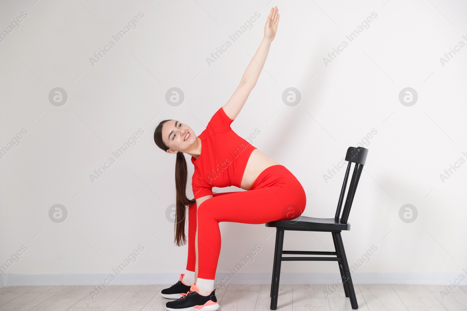 Beautiful woman stretching on chair at home Photo of Beautiful woman stretching on chair at home