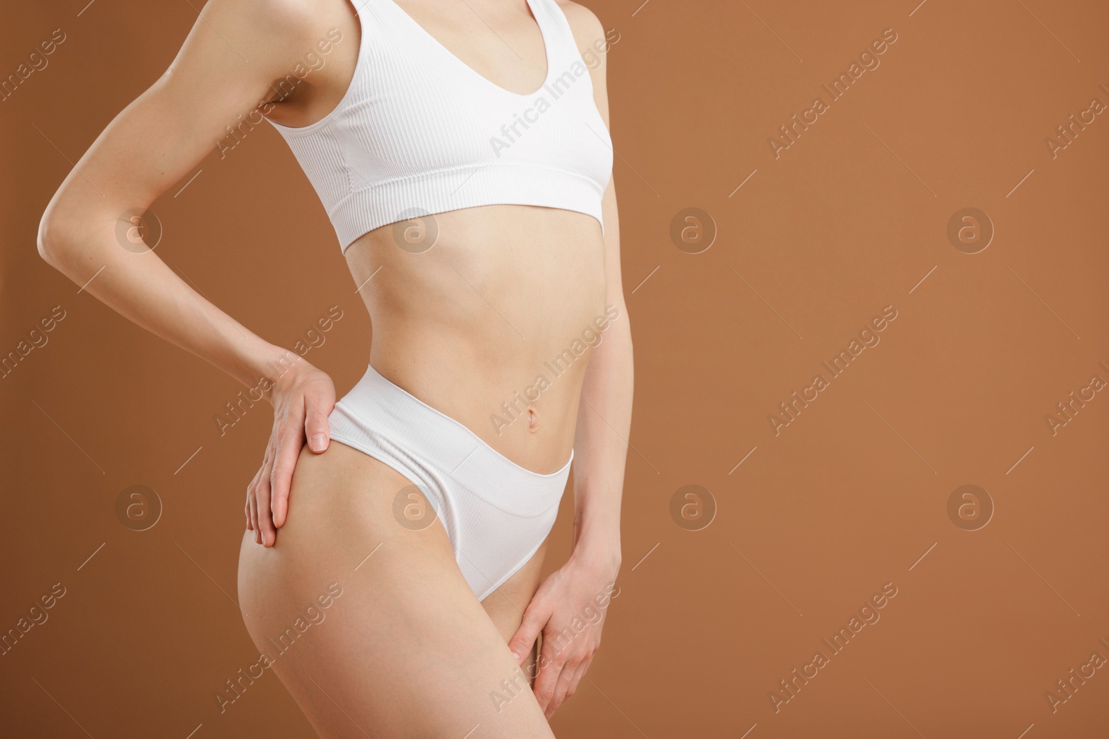 Woman with perfect slim body on beige background, closeup. Space for text Photo of Woman with perfect slim body on beige background, closeup. Space for text