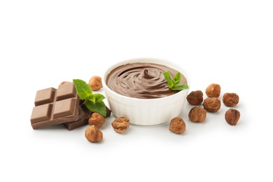 Photo of Tasty chocolate spread with mint in bowl and hazelnuts isolated on white
