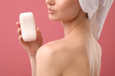 Photo of Woman with soap bar on pink background, closeup