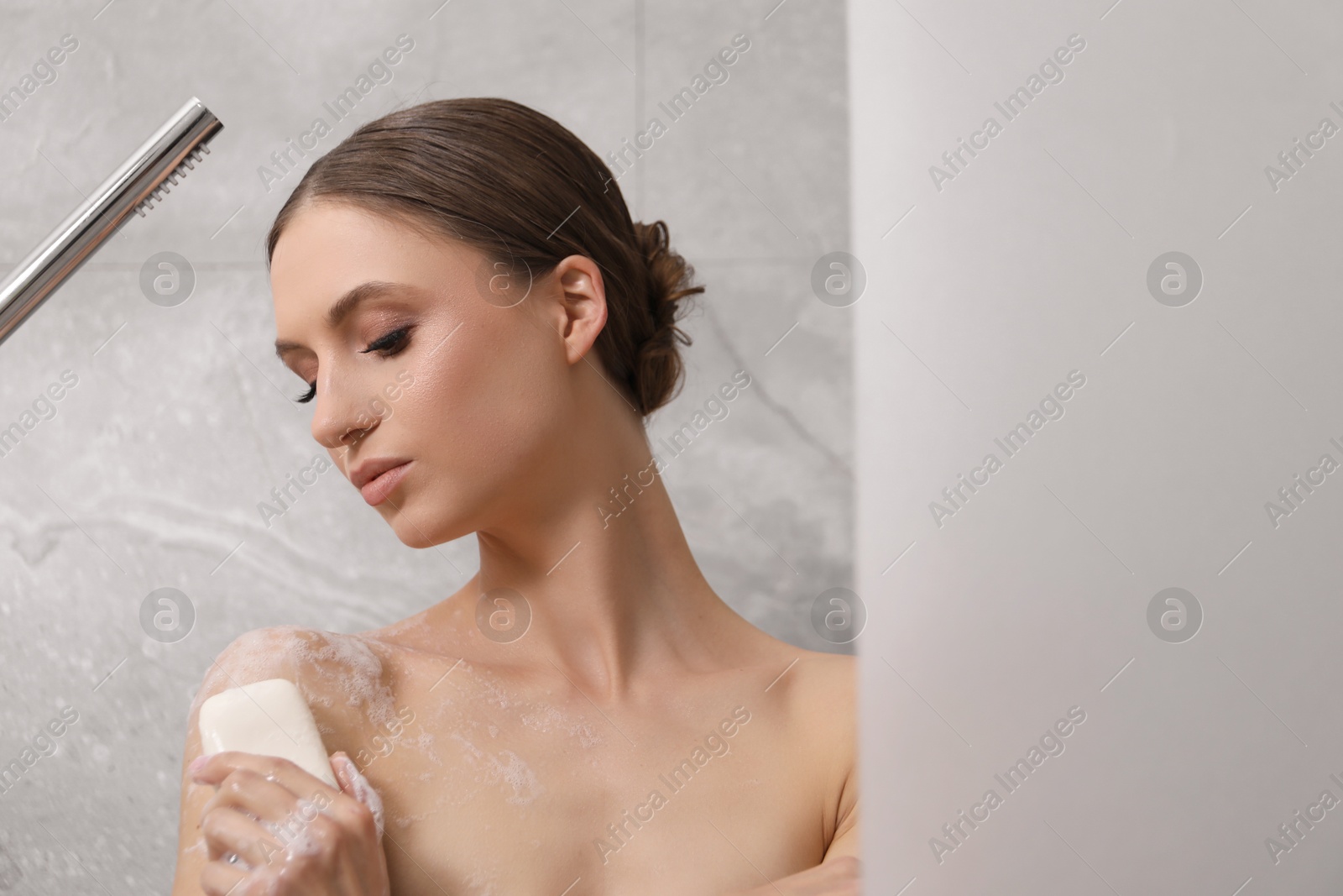 Woman washing body with soap bar in bathroom. Space for text Photo of Woman washing body with soap bar in bathroom. Space for text