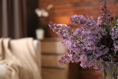 Photo of Beautiful lilac flowers in vase indoors, closeup. Space for text