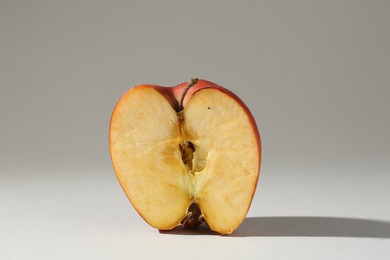 Photo of Half of damaged apple on light grey background