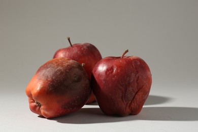 Photo of Damaged red apples on light grey background