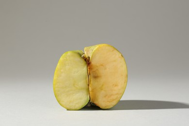 Photo of Half of damaged apple on light grey background
