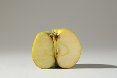 Photo of Half of damaged apple on light grey background