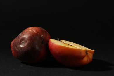 Photo of Damaged red apples on black background. Space for text