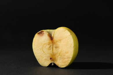 Photo of Half of damaged apple on black background