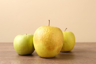 Photo of Many damaged green apples on wooden table