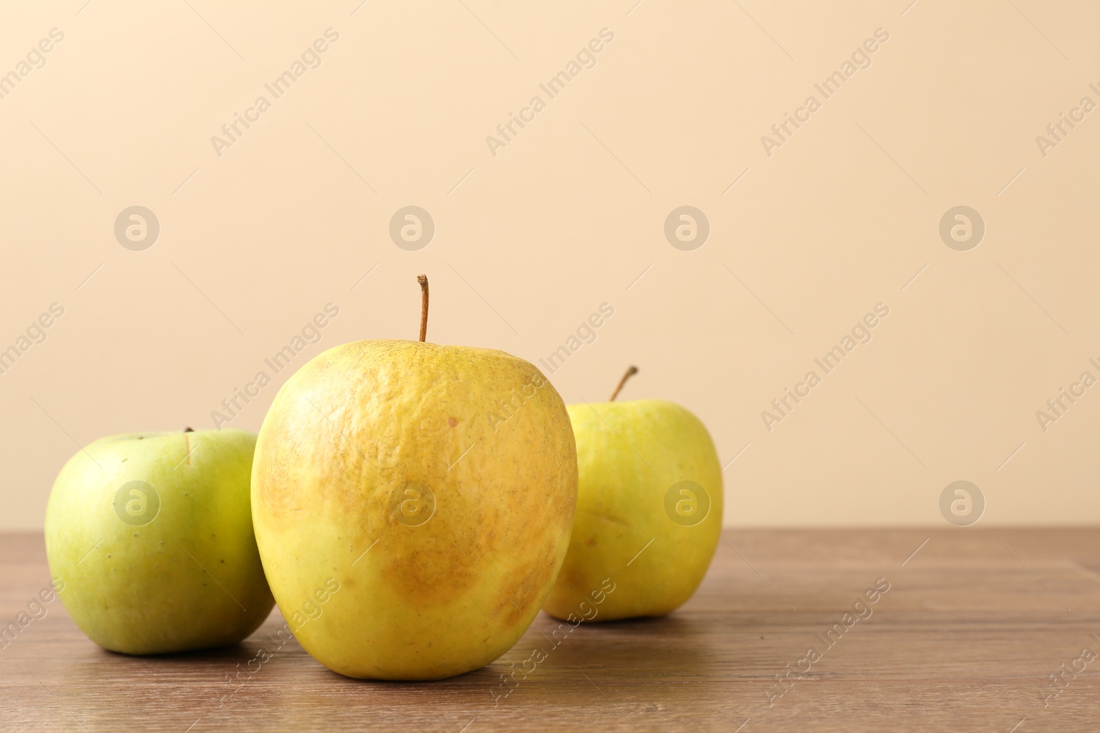 Many damaged green apples on wooden table. Space for text Photo of Many damaged green apples on wooden table. Space for text