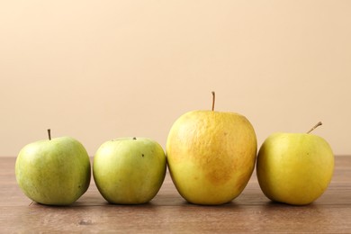 Photo of Many damaged green apples on wooden table. Space for text