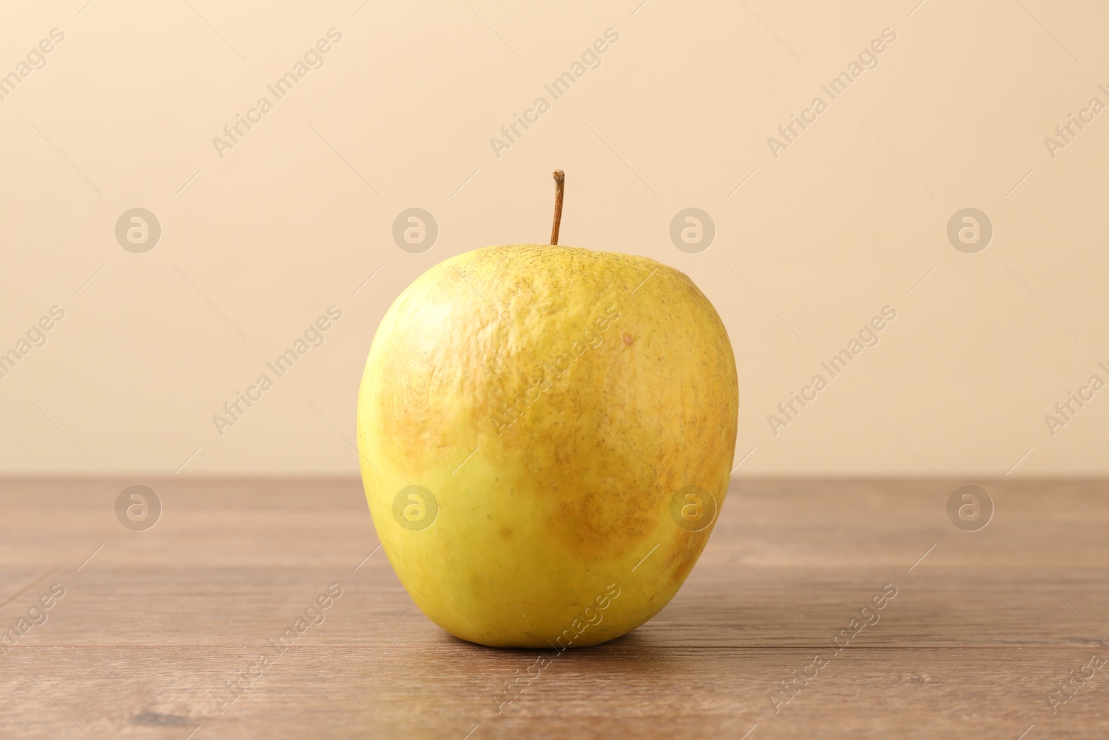 One rotten green apple on wooden table Photo of One rotten green apple on wooden table