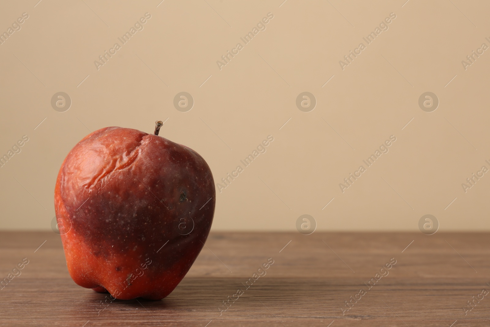 One rotten red apple on wooden table. Space for text Photo of One rotten red apple on wooden table. Space for text