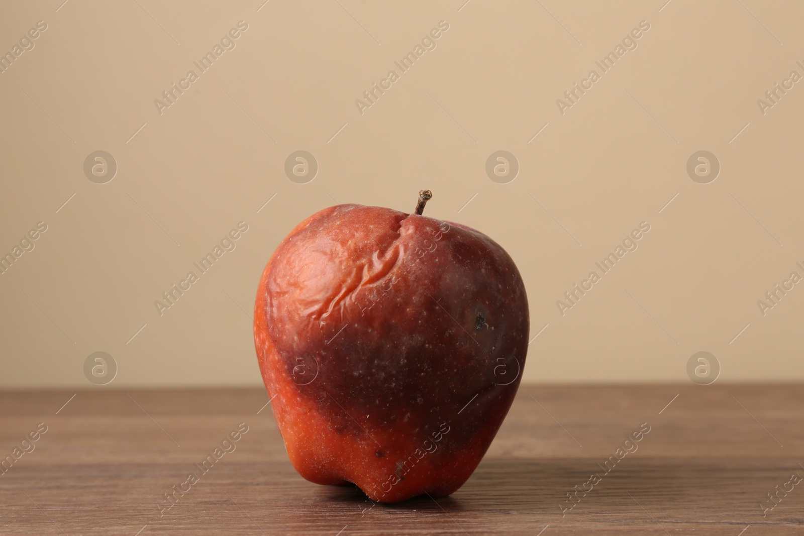 One rotten red apple on wooden table Photo of One rotten red apple on wooden table
