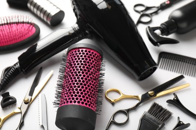 Photo of Different hairdresser's tools on light grey background, closeup