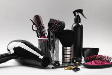 Photo of Different hairdresser's tools on light grey background, closeup