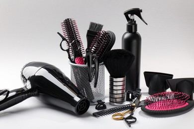 Photo of Different hairdresser's tools on light grey background, closeup