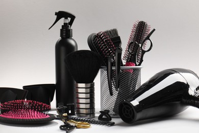 Photo of Different hairdresser's tools on light grey background, closeup