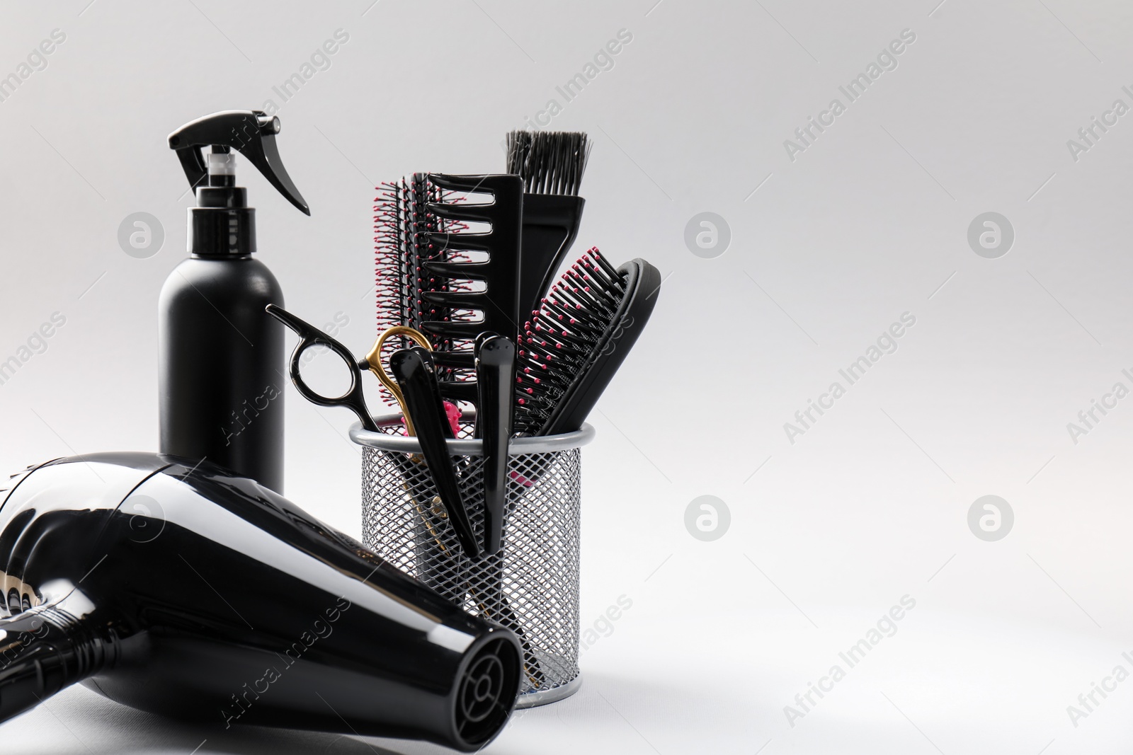 Different hairdresser's tools on light grey background, closeup. Space for text Photo of Different hairdresser's tools on light grey background, closeup. Space for text