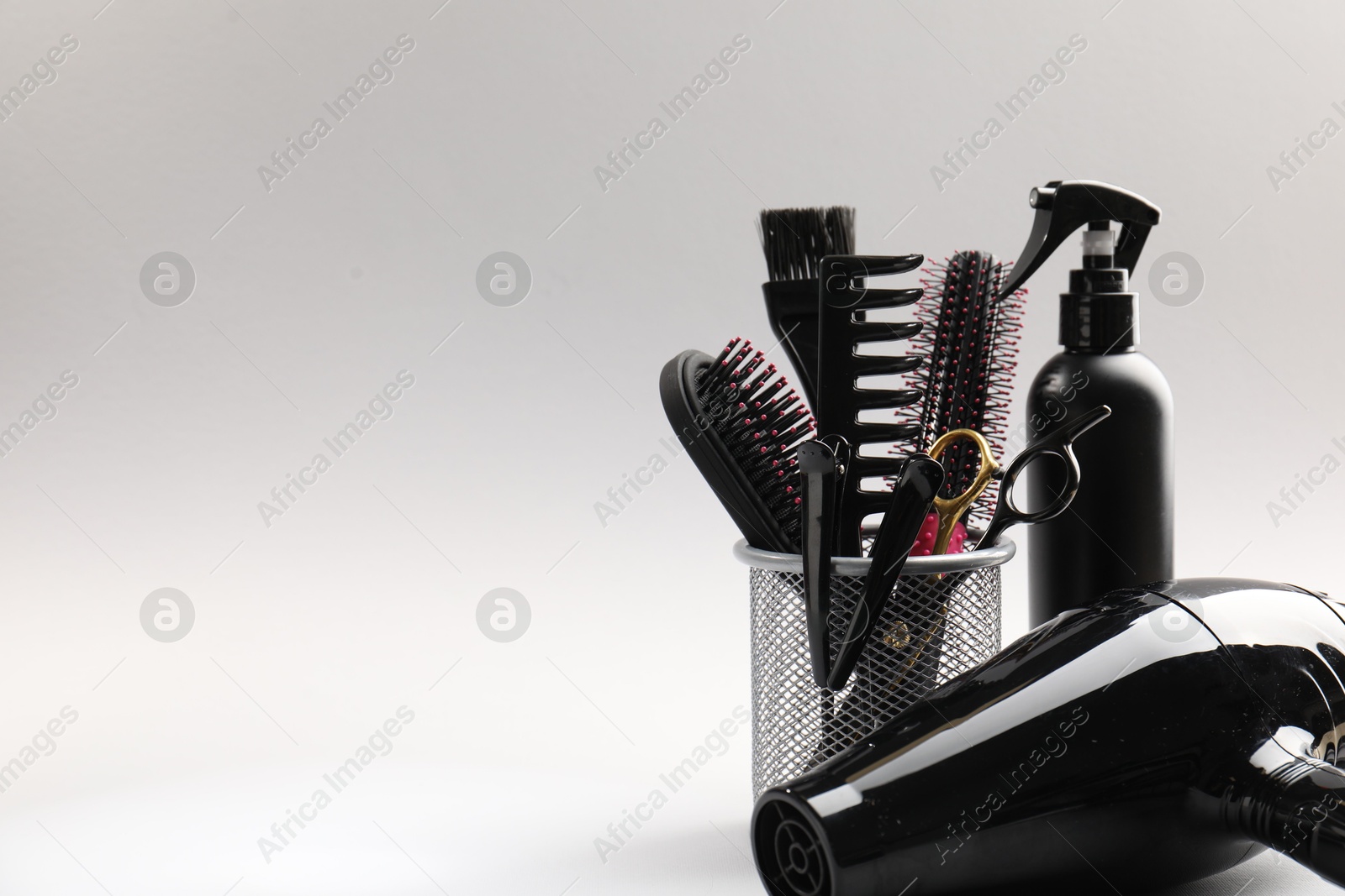 Different hairdresser's tools on light grey background, closeup. Space for text Photo of Different hairdresser's tools on light grey background, closeup. Space for text