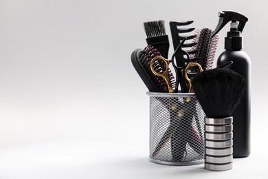 Photo of Different hairdresser's tools on light grey background, closeup. Space for text
