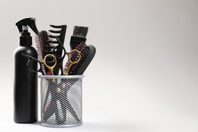 Photo of Different hairdresser's tools on light grey background, closeup. Space for text