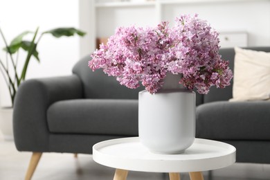 Photo of Beautiful lilac flowers in vase on table indoors, space for text
