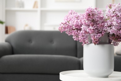 Photo of Beautiful lilac flowers in vase on table indoors, space for text