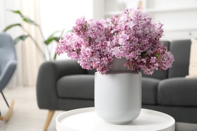 Photo of Beautiful lilac flowers in vase on table indoors, space for text