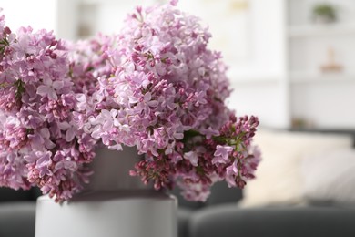 Photo of Beautiful lilac flowers in vase indoors, closeup. Space for text